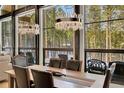 Elegant dining area with a long wooden table, leather chairs, and picturesque forest views at 55 Blue Flag Dr, Breckenridge, CO 80424