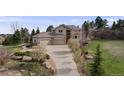 Beautiful home showcasing a stone facade, three-car garage, and lush landscaping at 6398 Lost Canyon Ranch Rd, Castle Rock, CO 80104