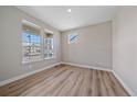 Well-lit bedroom with large windows, light-colored walls, and laminate wood flooring at 4880 River Landing Ave, Firestone, CO 80504