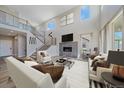 Stunning living room featuring high ceilings, fireplace, and staircase with metal railing at 4880 River Landing Ave, Firestone, CO 80504