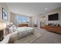 Bright main bedroom boasting large windows, dresser, and an ensuite bathroom at 4880 River Landing Ave, Firestone, CO 80504