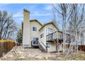 Spacious backyard with a raised deck, patio area, and mature trees, perfect for outdoor entertaining and relaxation at 3653 S Flanders St, Aurora, CO 80013