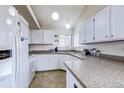 Bright kitchen with white cabinets, granite countertops, a window overlooking the backyard and tiled flooring at 3653 S Flanders St, Aurora, CO 80013