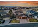 Two-story home with a two-car garage, surrounded by a lush lawn and other houses, with mountain views in the distance at 9845 Glenstone Trl, Highlands Ranch, CO 80130