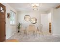 Cozy dining area with a glass table, woven chairs, and natural light from the window at 509 Newland St, Lakewood, CO 80226