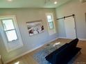 Bright living room with a modern ceiling fan, beautiful art, and a black futon couch at 2737 N Marion St, Denver, CO 80205