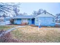 Blue house with a blue door and a well-maintained lawn at 202 9Th Ave, Longmont, CO 80501