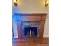 Close-up of the fireplace with hardwood mantle and tile surround at 7665 E Eastman Ave # 110C, Denver, CO 80231