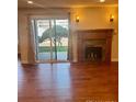 Bright living room with hardwood floors, fireplace, and sliding glass door to the outside at 7665 E Eastman Ave # 110C, Denver, CO 80231