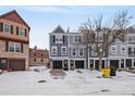 Townhome exterior, gray siding, black garage doors, and a snowy street at 12018 E Tennessee Dr, Aurora, CO 80012