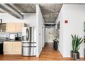 Modern kitchen featuring stainless steel appliances, and a hallway with hardwood floors and stylish artwork at 1499 Blake St # 6A, Denver, CO 80202