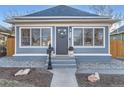 Close-up of attractive single-Gathering home entrance with tidy landscaping, a wreath, and covered porch at 722 Kimbark St, Longmont, CO 80501