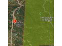 An aerial view shows the property boundaries in a forested area with the City & County of Denver in the background at 8724 Armadillo Trl, Evergreen, CO 80439