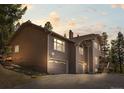 Charming two-story home with a two car garage and classic design features at dusk at 8724 Armadillo Trl, Evergreen, CO 80439