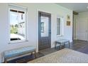 Bright entryway with a glass door, hardwood floors, bench seating, and neutral decor at 609 Pioneer Camp Vw, Palmer Lake, CO 80133