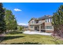Expansive backyard with a well-manicured lawn, solar panels, mature trees, a patio, and a charming wooden fence at 19096 W 53Rd Pl, Golden, CO 80403