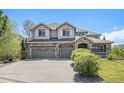 Beautiful two-story house with a stone facade, three-car garage, inviting front porch, and well-maintained landscaping at 19096 W 53Rd Pl, Golden, CO 80403