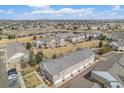 Aerial view of townhomes near a pond, showcasing green spaces and well-kept exteriors in a neighborhood setting at 12710 Jasmine St # C, Thornton, CO 80602