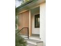 Stylish porch features vertical wood slats, sleek black railings, and painted white brick at 4631 Zuni St, Denver, CO 80211