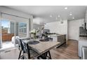 Open-concept kitchen and dining area with stainless steel appliances, gray cabinets, granite counters, and wood floors at 933 Canal West Dr, Brighton, CO 80603