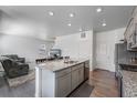 Bright kitchen with granite countertops, stainless steel appliances, grey cabinets, and an open view to the living room at 933 Canal West Dr, Brighton, CO 80603