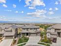 An aerial view of a home showing the neighborhood, a greenway and mountains in the distance at 16371 Jones Mountain Way, Broomfield, CO 80023