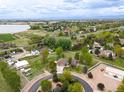 Expansive aerial view of a home surrounded by lush greenery with white fencing and neighboring properties nearby at 3784 Whitetail Ct, Mead, CO 80542