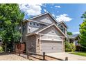 Side view of a charming two-story home with a two-car garage, showcasing its exterior details at 664 Clarendon Dr, Longmont, CO 80504