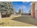 A spacious, level backyard surrounded by a wooden fence and mature trees provides privacy and space for outdoor activities at 7867 S Poplar Way, Centennial, CO 80112