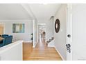 Bright and inviting foyer with hardwood floors, staircase, and an open doorway to the dining room at 7867 S Poplar Way, Centennial, CO 80112