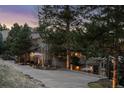 Long paved driveway leading to a luxury two-story home surrounded by trees at 22419 Springflower Dr, Golden, CO 80401