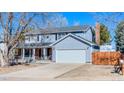 Two-story home with a covered porch, two car garage, and a long driveway in a residential neighborhood at 1109 E 7Th Avenue Cir, Broomfield, CO 80020