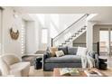 Inviting living room bathed in natural light featuring a cozy seating area and staircase at 6068 Beeler Ct, Denver, CO 80238