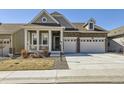 Charming home featuring a stone and siding exterior, covered porch, and a two-car garage at 15747 Willow Way, Thornton, CO 80602