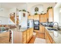 Open kitchen with center island, stainless appliances, and staircase leading to the upper level at 1851 Ute Creek Dr, Longmont, CO 80504