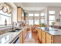 Kitchen with granite countertops, island cooktop, stainless appliances, and window-filled breakfast nook at 1851 Ute Creek Dr, Longmont, CO 80504