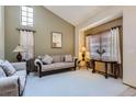 Bright living room features high ceilings, neutral walls, plush carpeting, and comfortable seating at 4933 Altura St, Denver, CO 80239