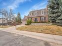 Beautiful brick home with a two-car garage, mature trees, and a well-kept lawn at 7426 S Hudson Way, Centennial, CO 80122