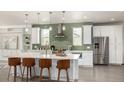 Bright kitchen with white cabinets, stainless steel appliances, a large island and unique backsplash at 3350 S Eudora St, Denver, CO 80222