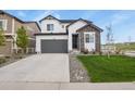 Charming two-story home with stone accents, a gray garage door, and well-maintained landscaping at 5446 Coltin Trl, Castle Rock, CO 80104