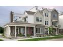 Attractive modern townhome showcasing a mix of brick and siding, complemented by a covered porch and second-story deck at 888 S Valentia St # 103, Denver, CO 80247