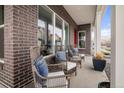 Comfortable front porch seating area with wicker chairs, decorative pillows, and a view of the neighborhood at 888 S Valentia St # 103, Denver, CO 80247