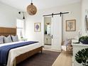 Main bedroom with sliding barn door to the bathroom and a coastal vibe at 888 S Valentia St # 103, Denver, CO 80247