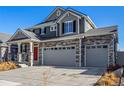 Lovely two-story home featuring stone accents, inviting front porch, and a grey two car garage at 4104 N Picadilly Ct, Aurora, CO 80019
