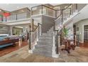 Grand foyer showcases a sweeping staircase with dark wood railings, and stone tile leading to the living spaces at 7672 S Ensenada Ct, Centennial, CO 80016