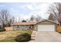 Charming single-story home with a well-maintained front yard and attached two-car garage at 6567 S Elizabeth Way, Centennial, CO 80121