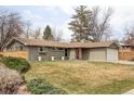 Lovely home featuring a well-kept lawn, gray brick exterior, and a driveway leading to the garage at 6567 S Elizabeth Way, Centennial, CO 80121