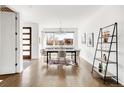 Bright dining room with hardwood floors, modern light fixture and a large window with neighborhood views at 3333 Osage St, Denver, CO 80211