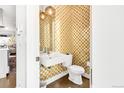 Stylish powder room with patterned wallpaper, floating sink, modern toilet and globe pendant lights at 3333 Osage St, Denver, CO 80211