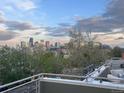 Breathtaking rooftop view showcasing the Denver skyline under a cloudy sky, framed by trees at 3333 Osage St, Denver, CO 80211